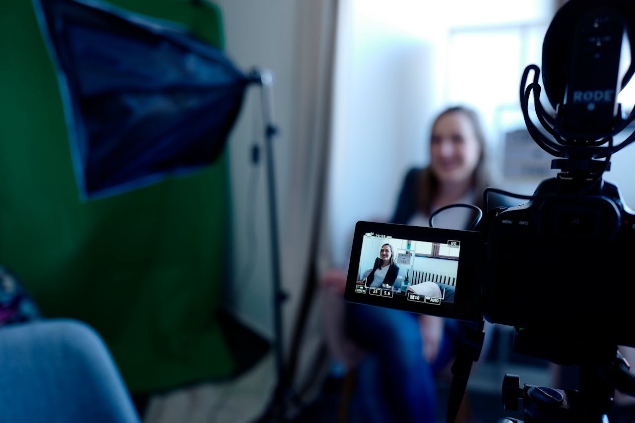 Accueil Woman being recorded in a professional studio setup, using video camera and lighting equipment.